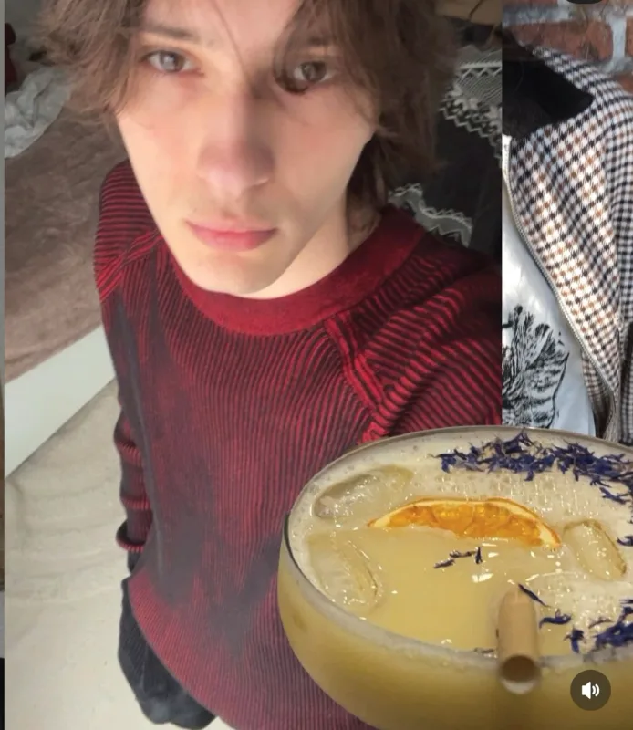 Andrei in een bordeauxrode trui naast een cocktail met gedroogde sinaasappel en bloemblaadjes, uit zijn Instagram-carrousel.