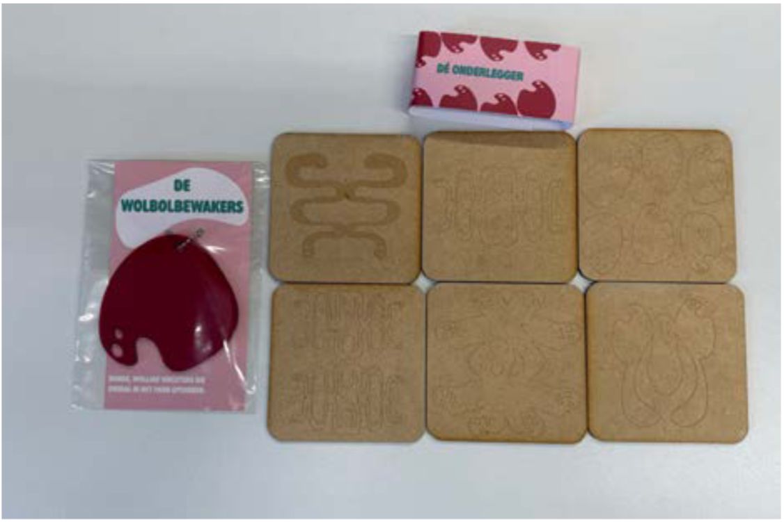 Productfotografie met bedrukte en gegraveerde objecten: onderleggers, een verpakking en een rode hanger.
